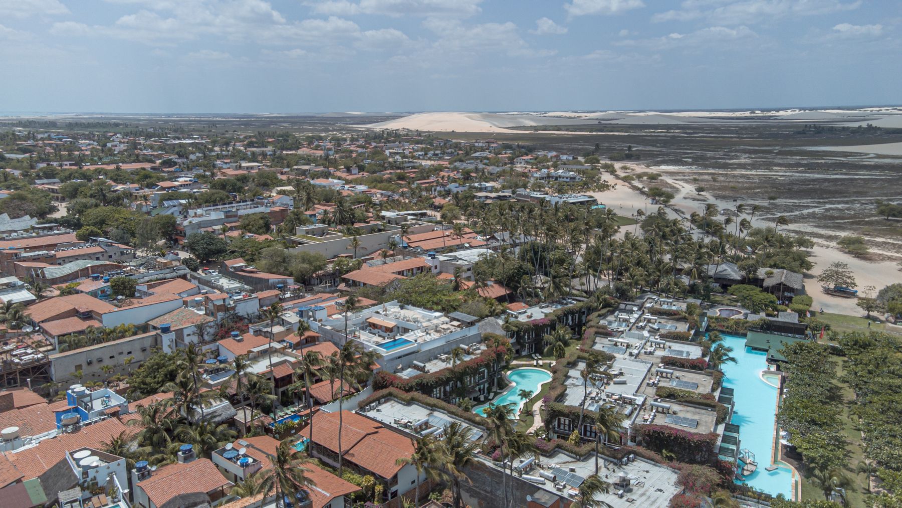 Vista aérea da vila de Jericoacoara entre dunas e coqueiros